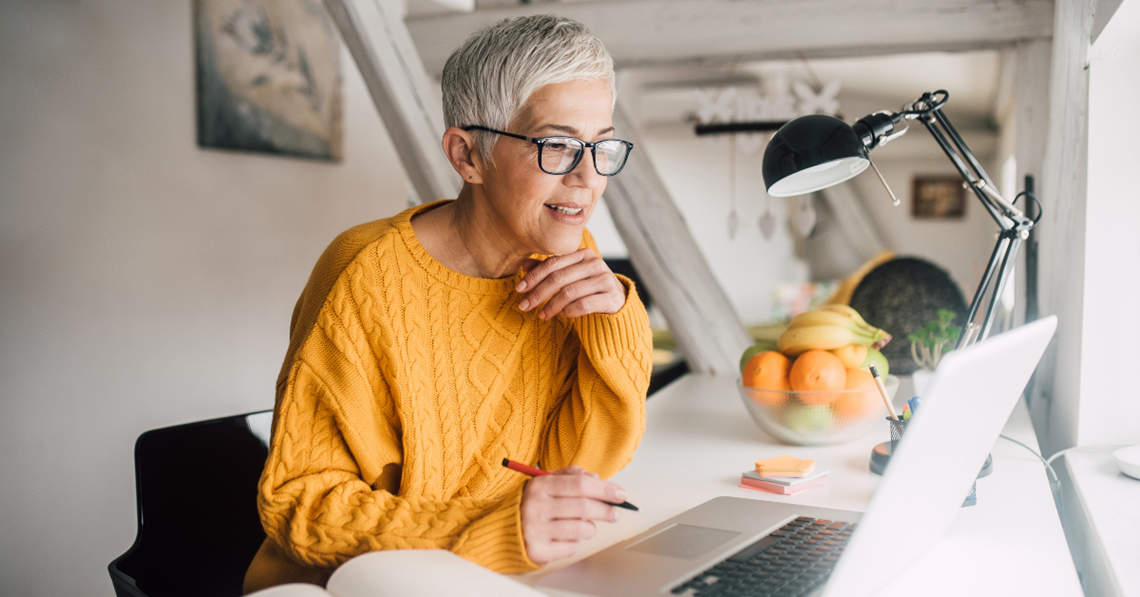 Senior kvinde ved skrivebord og computer